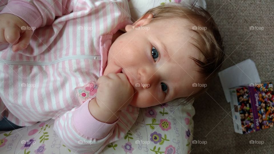 baby girl discovering her hands at 3 months old