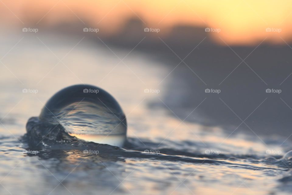 Using the lens ball to see the movement of the ocean waves on the beach at sunrise