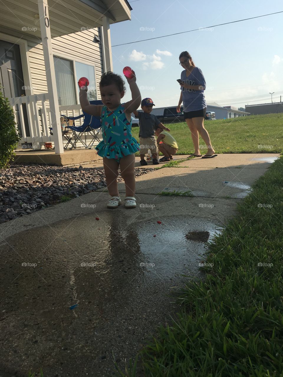 Toddler girl water ballon play :) it was 85 degrees which was perfect for water play outside! She is about to break her balloons 