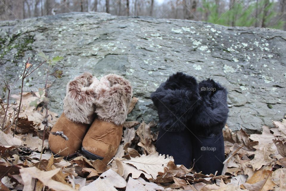 Buckskin and Black Slippers leaning on rock