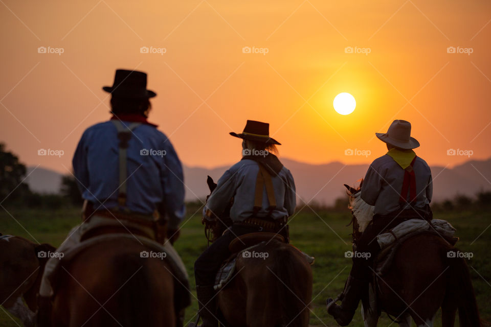 man riding horse against sunset