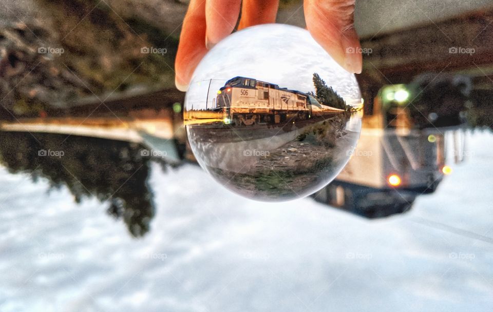 captured a moving train by the beach in a spherical glass ball