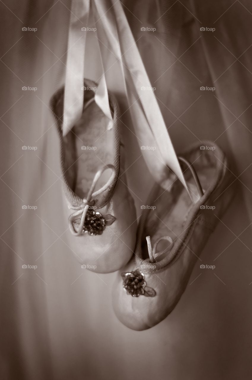 Sepia image of dance shoes hanging