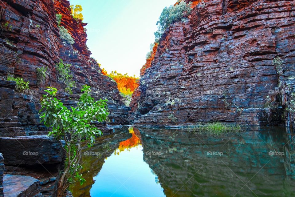 Rocky gorge and sky reflected in water 