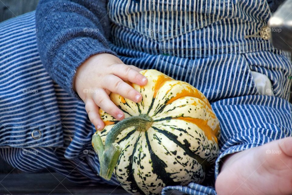 Baby holding pumpkin