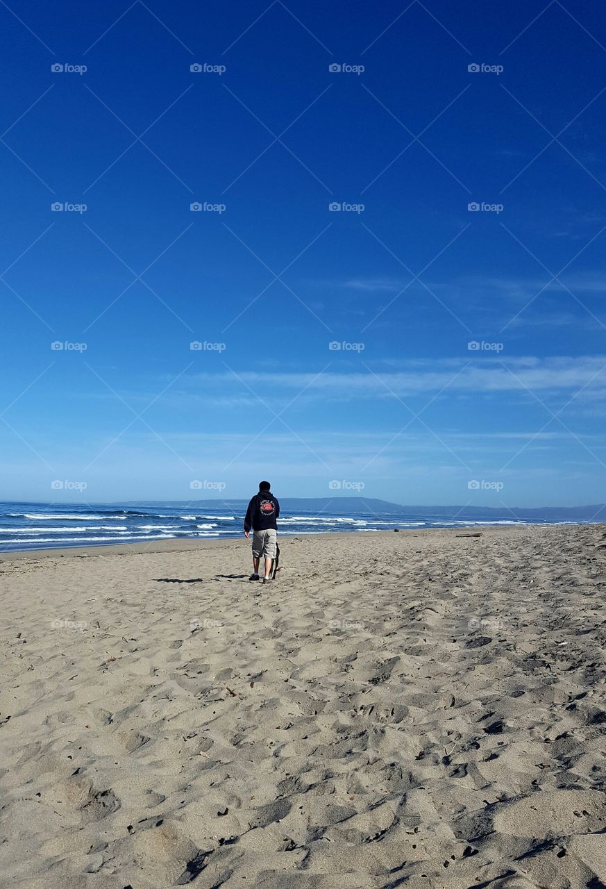 my son walking his dog on the beach in Watsonville, CA