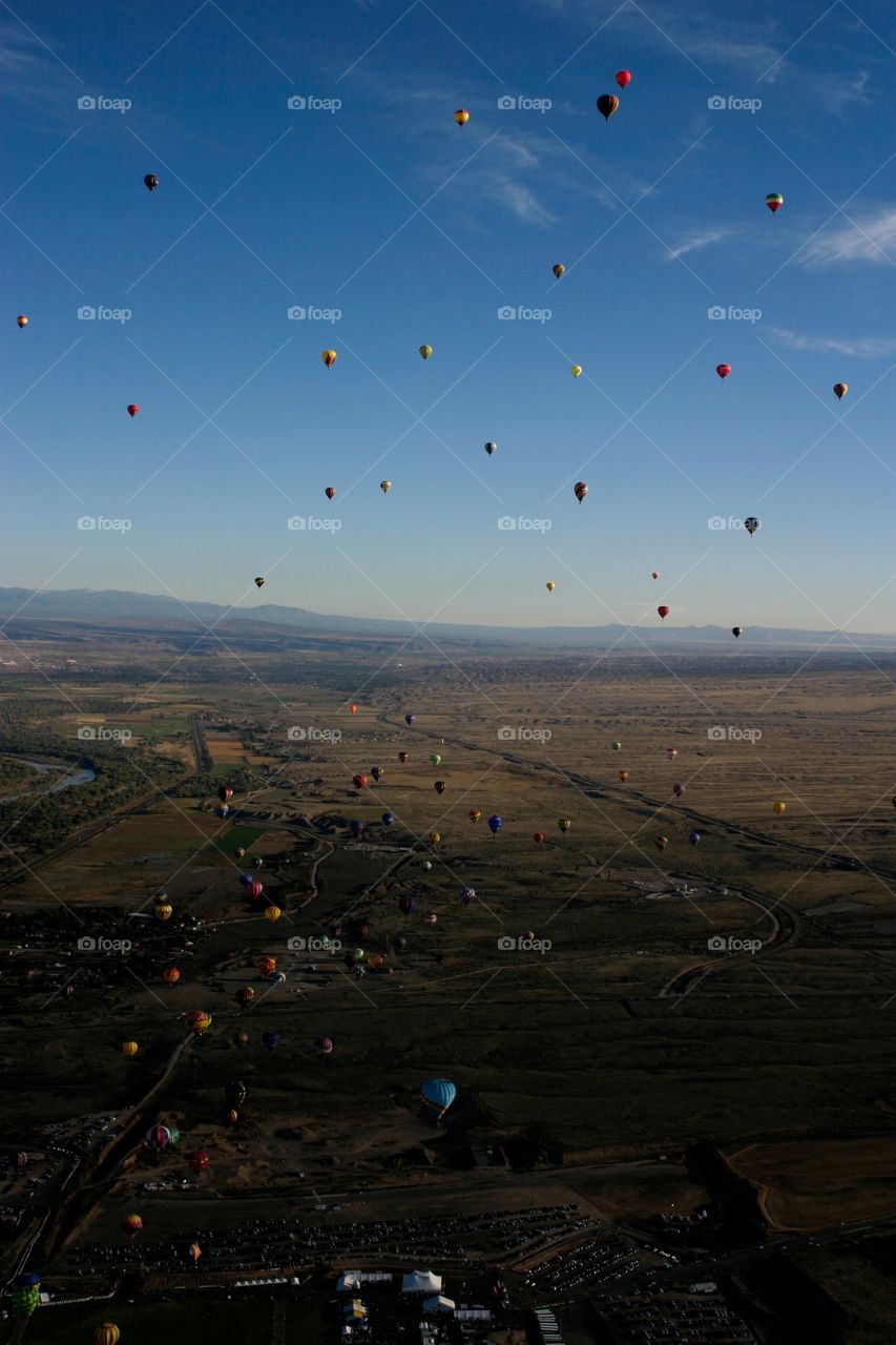 Air view of hot air balloons against desert landscape 