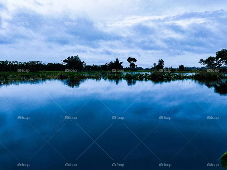 I took this photo myself.  There is water in the river and clouds in the sky.  This landscape looks very beautiful.  This river of our village is very beautiful.