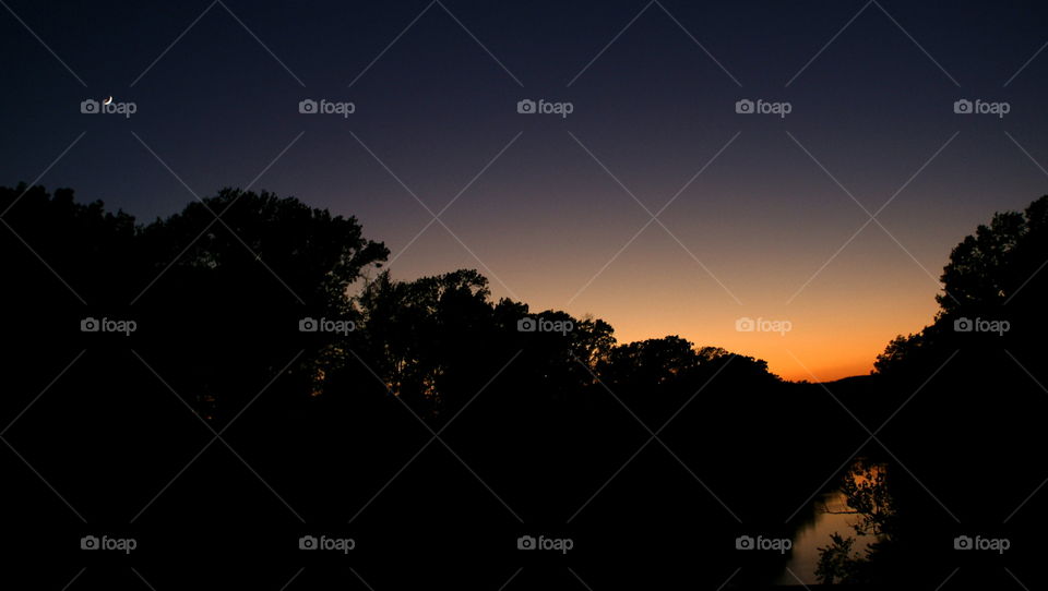 crescent moon over a sunset
