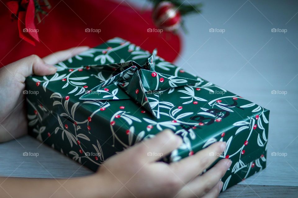 Child's hands are holding her Christmas present