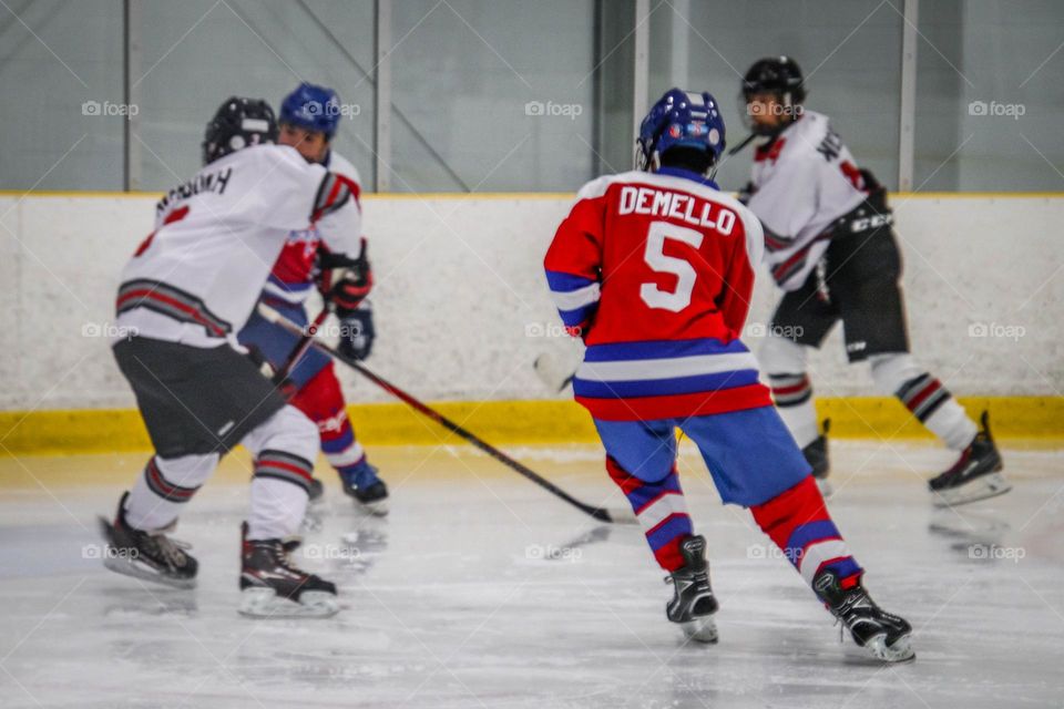 Teen boys are playing ice hockey