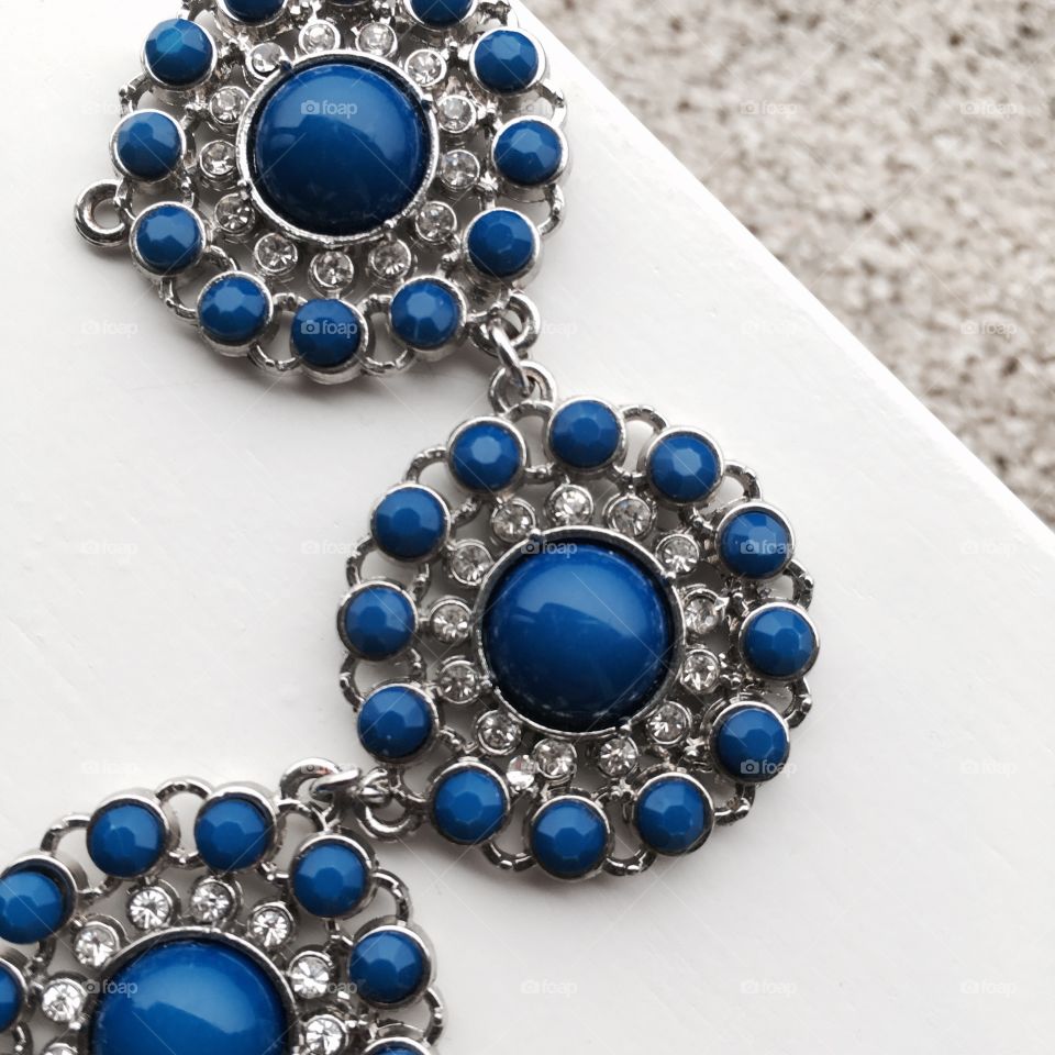 This piece of a blue necklace shows the contraste between blues , whites and greys . 