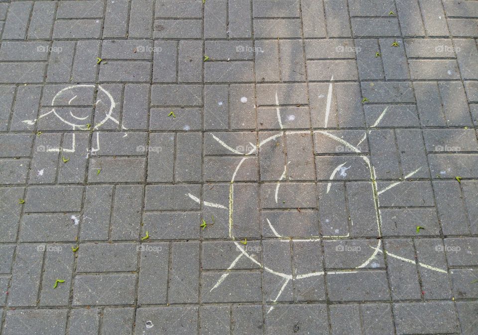 drawing  smiling sun on a street pavement