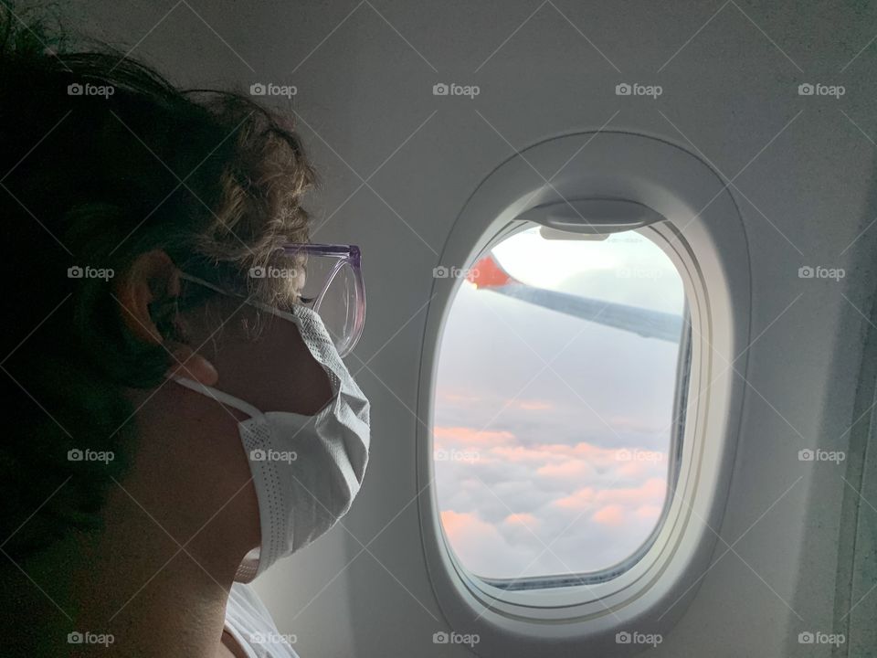 girl looking through airplane window