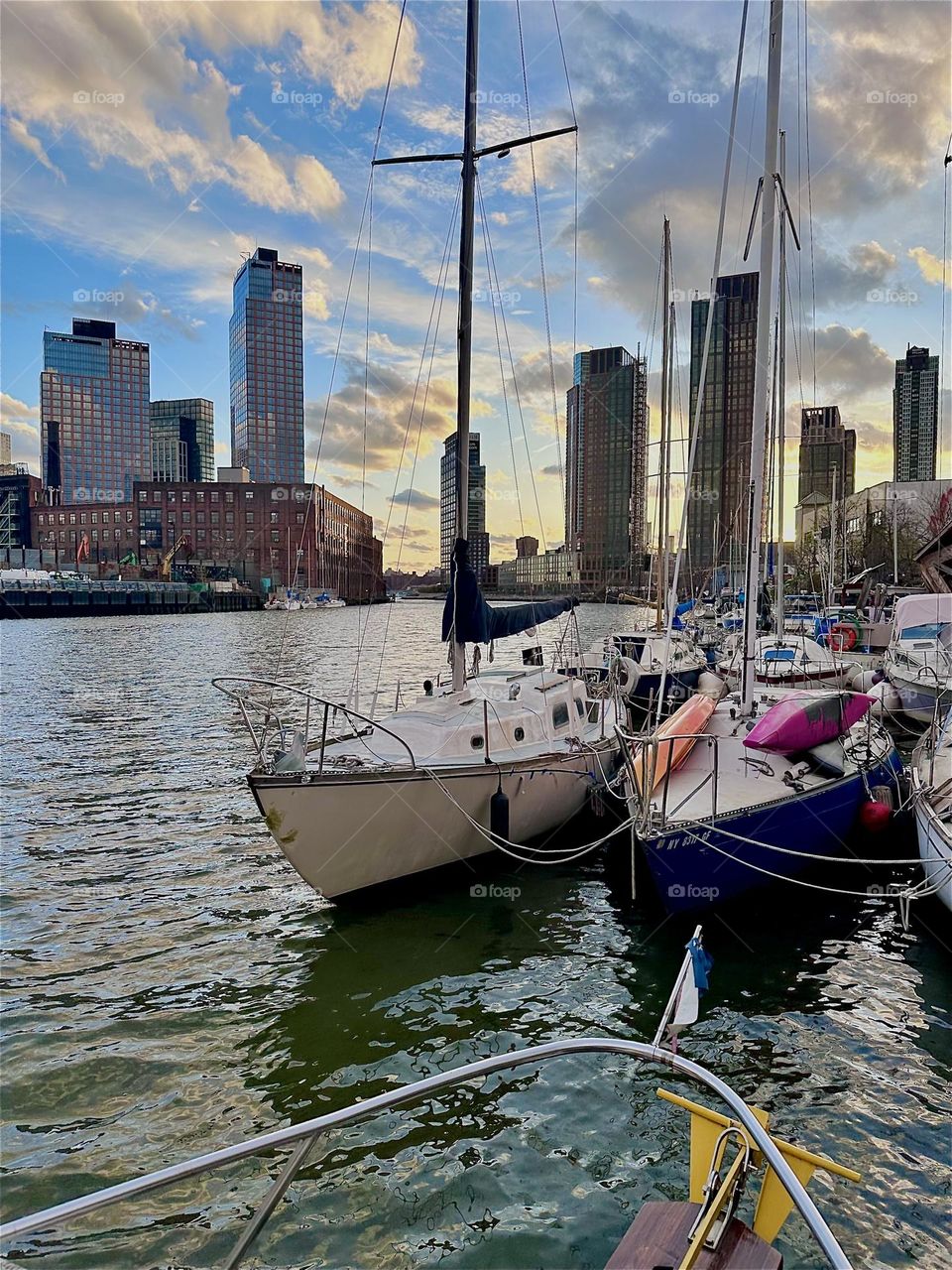 This is “Newtown Creek” by the “Pulaski Bridge” in LIC, Queens with various boats that are moored here. The water of the “E River” shimmers in bright silver intensified by the silver clouds above reflecting back and forth. 2024. Hypnotic Productions