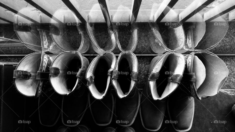 Botas e o reflexo na parede de vidro.