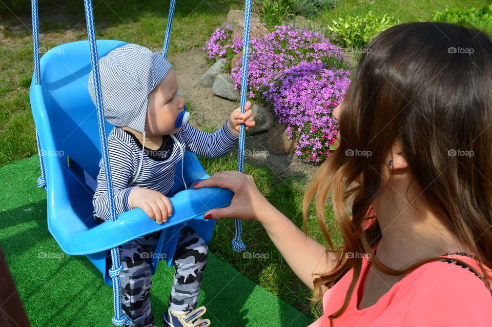 Boy on a swing with mommy