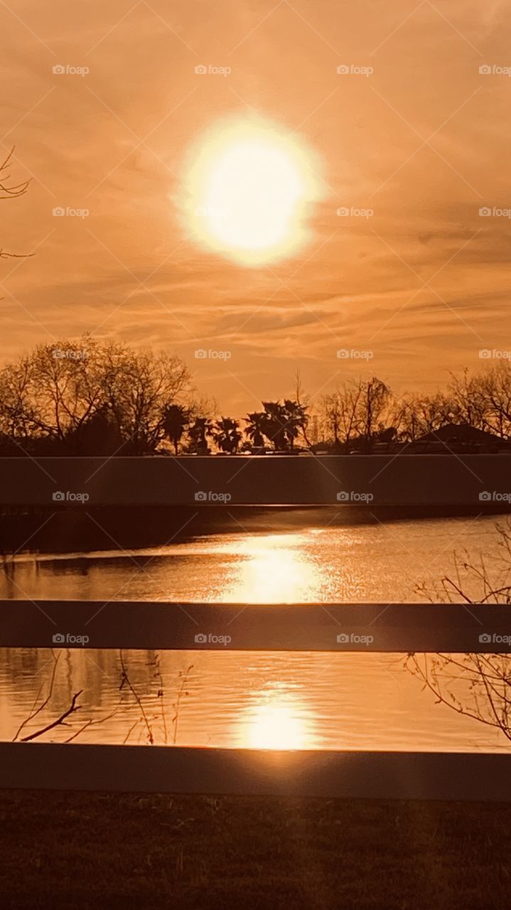 Evening Sunset high clouds spreading the sunbeams with the clouds. Evening colors appear strong for this early pic. Reflections of the Sunbeams /  Rays off the lake waters. 