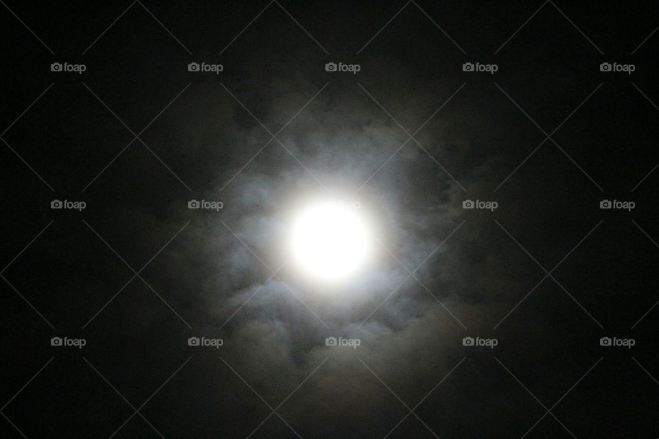 night photography. Moon. Clouds. light. sky. night sky. looking up at the moon in the night sky as clouds pass by.