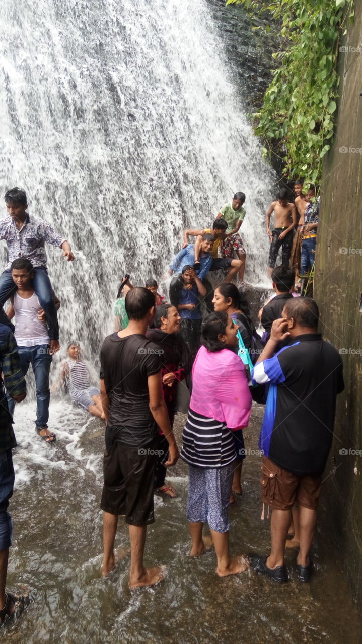 people enjoying in waterfall.