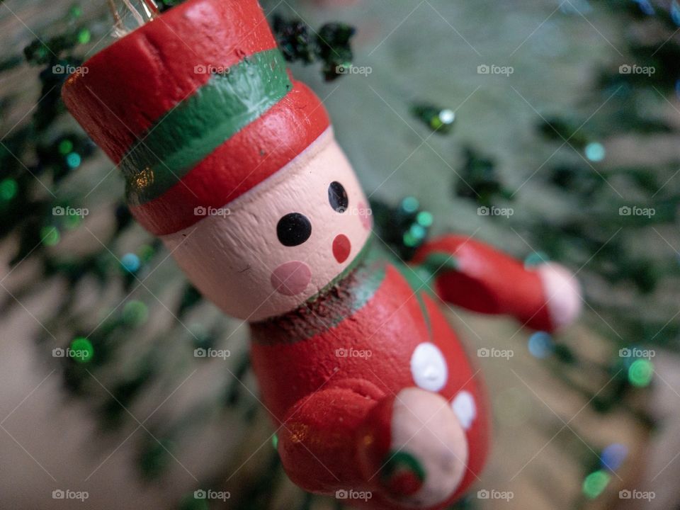 Red and green wooden Christmas figure hanging in a Christmas tree