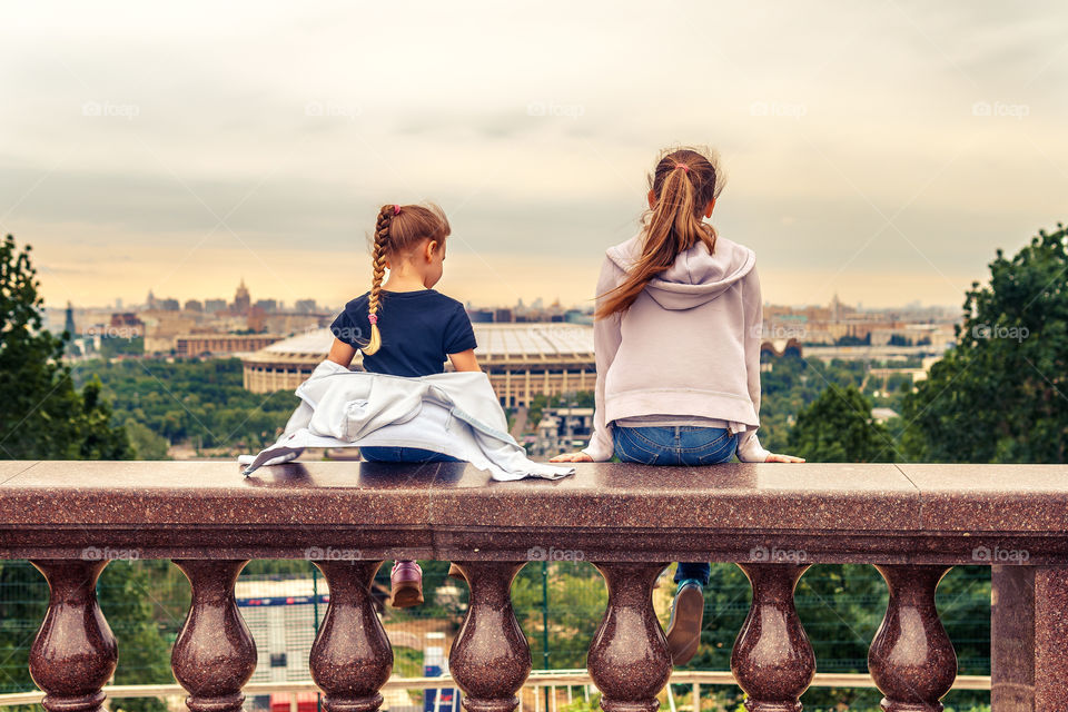 Kids are sitting, and watching the city