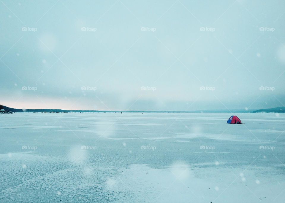 Winter fishing on frozen lake 