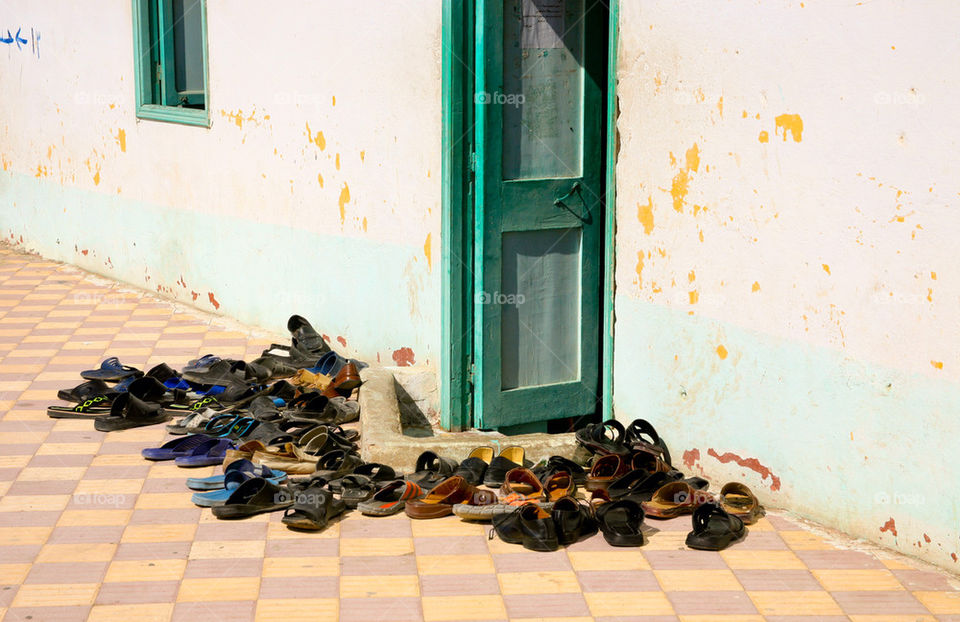 Shoes in front of a mosque door.