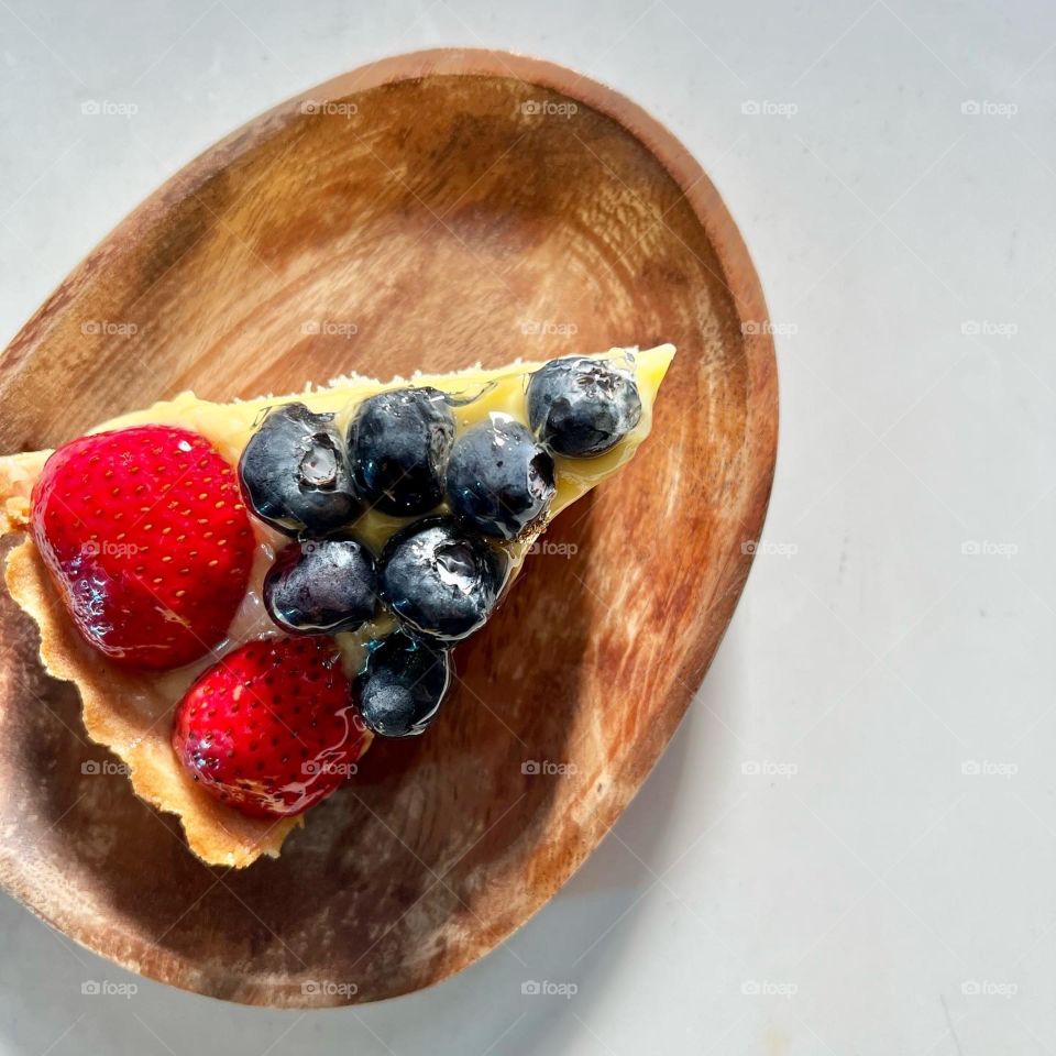 Strawberry blueberry fruit tart in custard and cake batter 