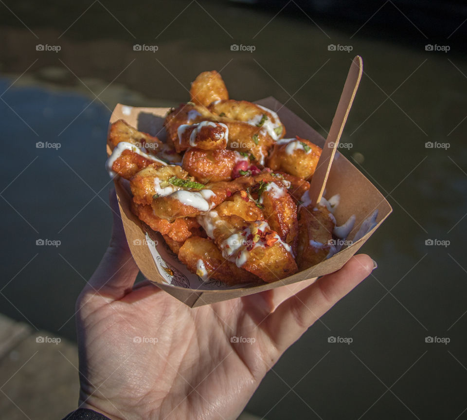 Person holding fried Halloumi cheese in bowl