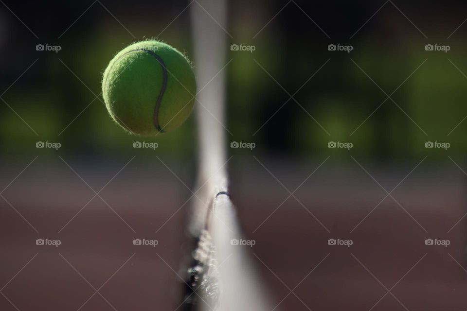 Tennis ball is flying over the net