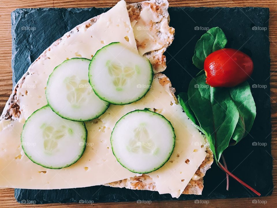 Tabletop with sandwich with cheese and cucumber