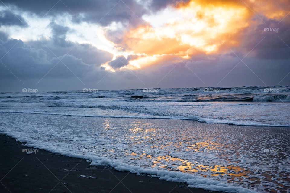 Beautiful sunset at the beach, sunlight reflects in the water