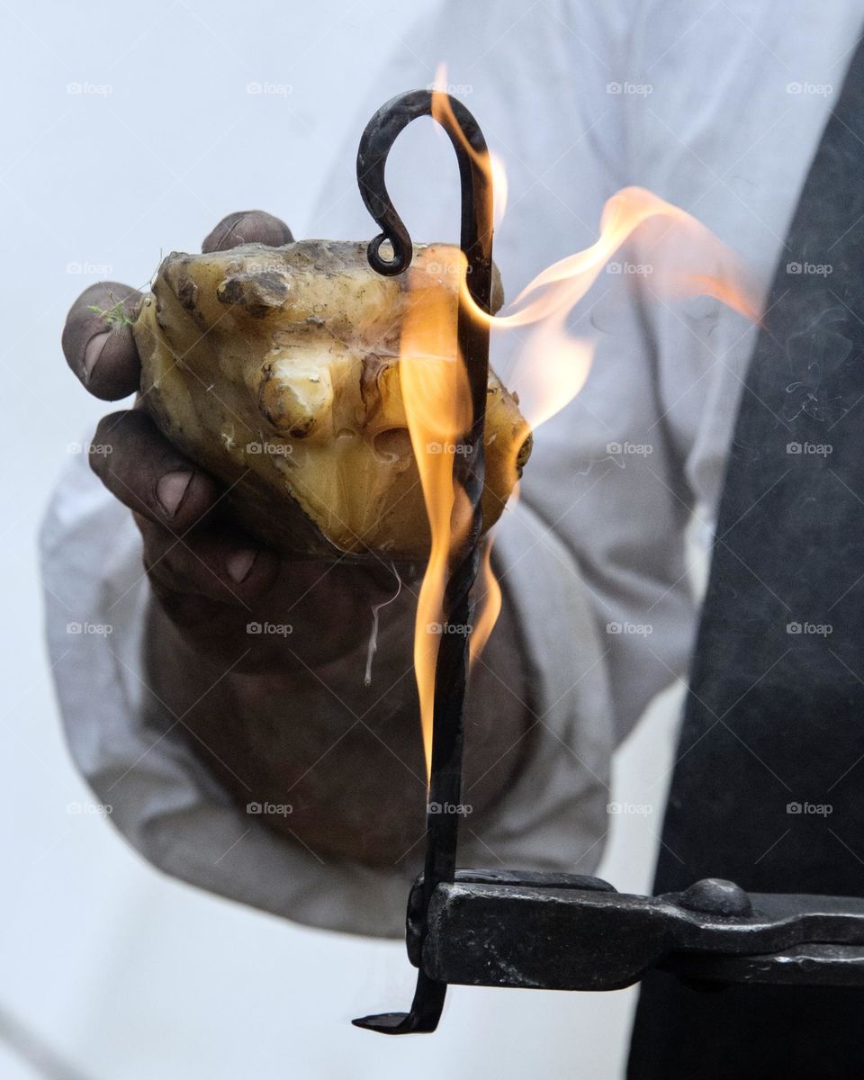 Blacksmith putting beeswax on hot metal