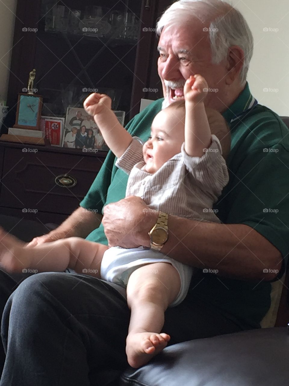 Baby boy sitting on grandfather's lap