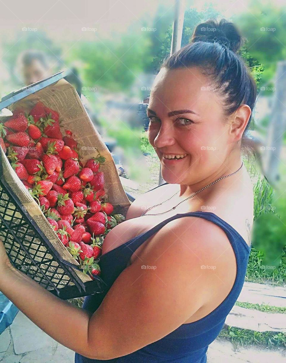 girl picked a box of strawberries from the field