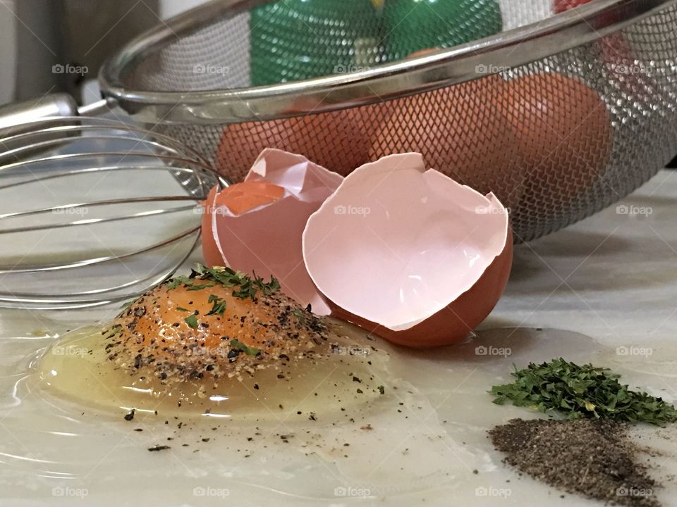 Farm fresh raw brown egg and egg shell on kitchen counter closeup 