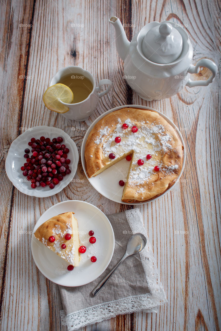 Cheesecake with cranberries and sugar on wooden background