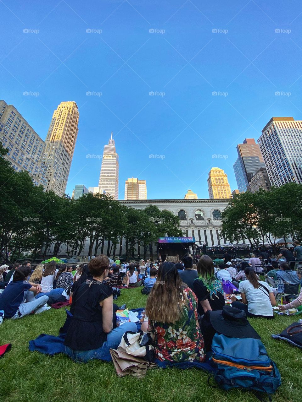 People watching and listening Opera and picnic at Bryant Park New York City.