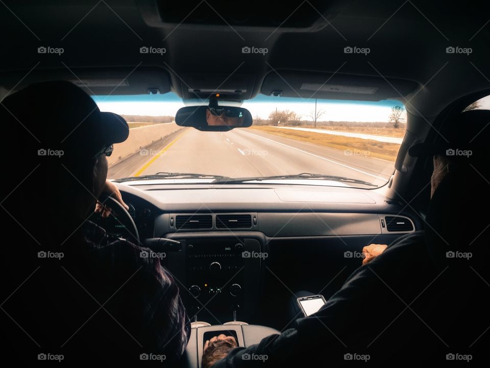 Two men driving down the road in silhouette