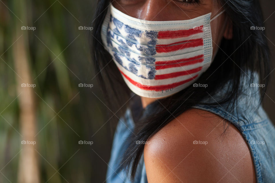 Beautiful brunette in a protective mask painted by the American flag.  Independence Day in America.  Flag.  Love.  A life.  The mask is made by hand