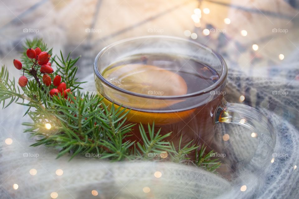 mug of hot tea with lemon and juniper sprigs