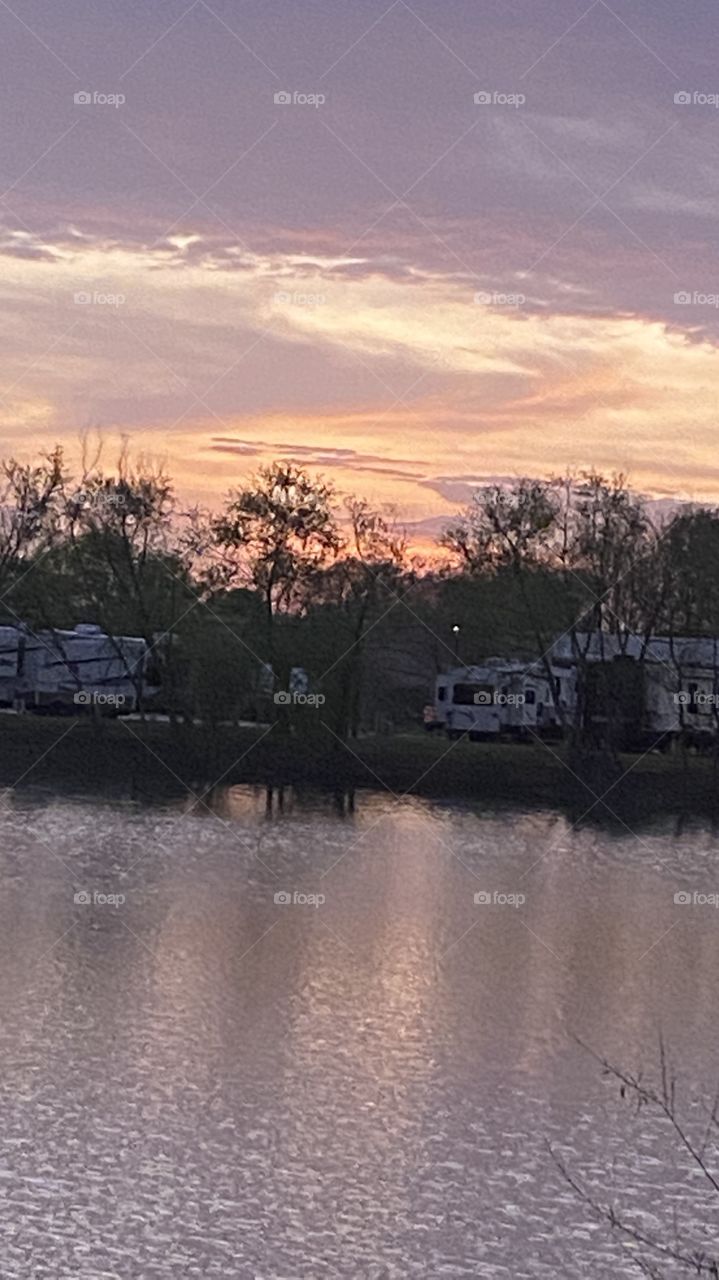 Sundown completed twilight in effect winding down bright colors of blue violet deep pink yellow white all add to the lasting Beauty of this photo not to mention the reflections of the colors on Lake Waters. 