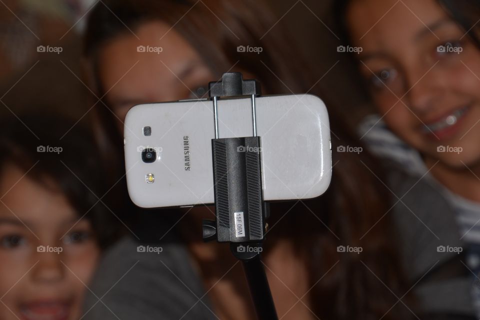 Three girls taking  a selfie with a selfie stick