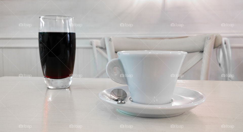  A cup of coffee with a glass of juice. drinks on a table in the bar