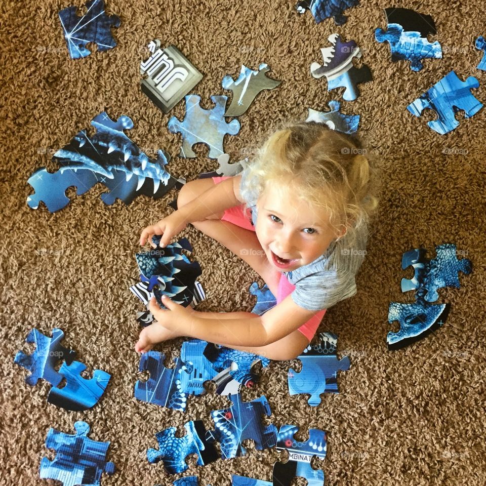 Girl making puzzle in house