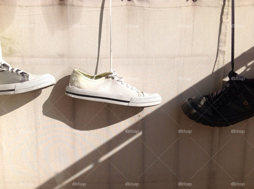 white shoes sneakers hanging by lexlebeur