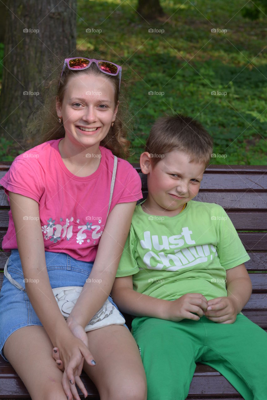 children on a bench in the summer city park