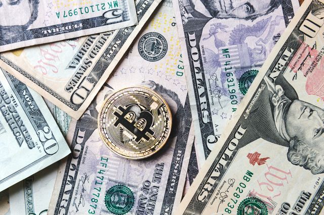Moneda de Bitcoin en billetes de dinero en efectivo