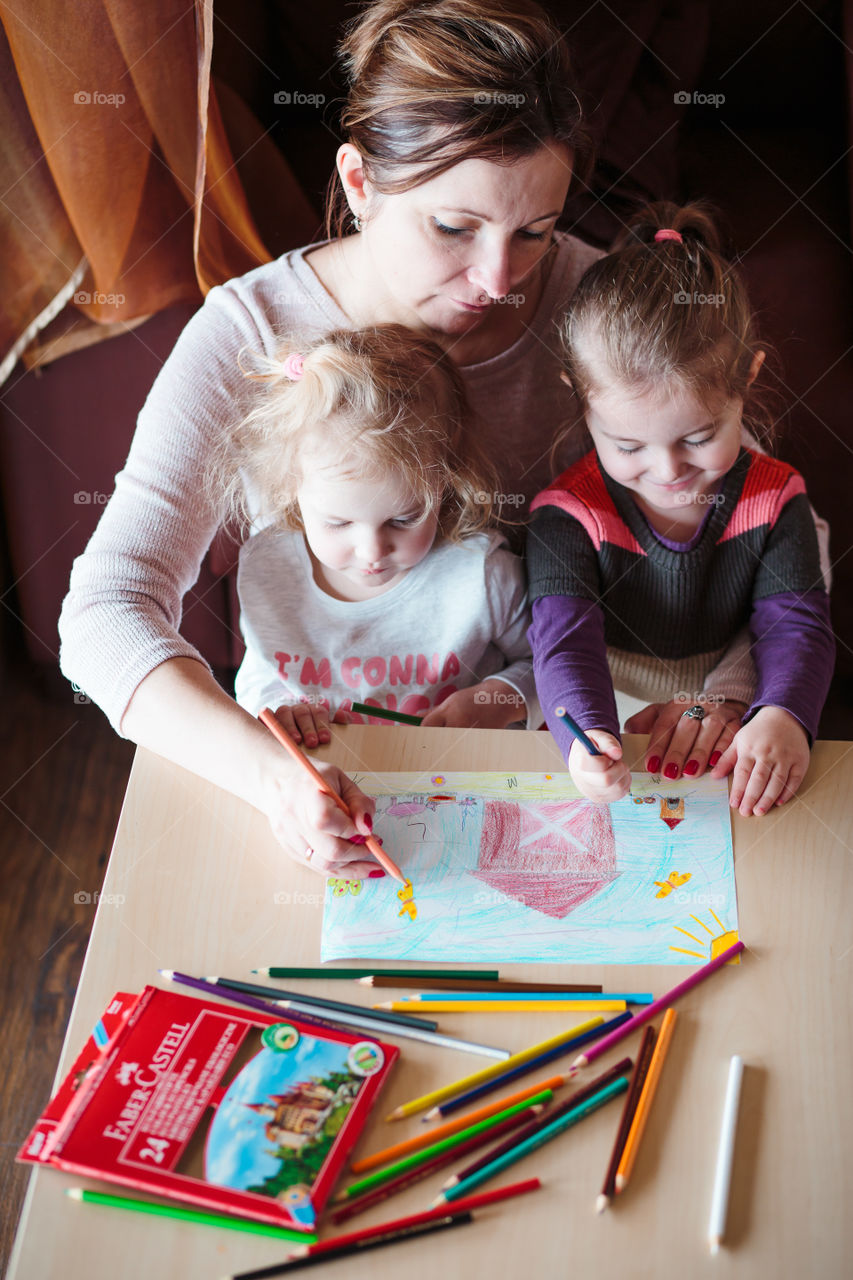 Colours of the world. Children with mom drawing using crayons